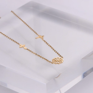 Golden stainless steel necklace featuring cutout flower, cross and heartbeat pendants