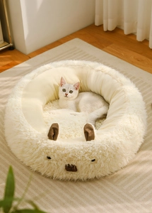 Close-up of white cat sleeping in a soft plush capybara-themed round pet bed