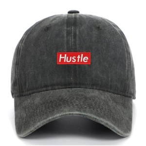 Close-up of a vintage washed baseball cap featuring a red Hustle embroidered patch