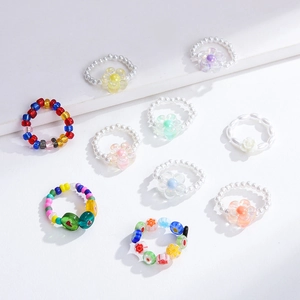 Flat lay of colorful handmade resin flower beaded rings set in bohemian style