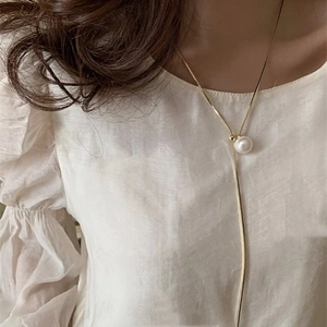 Elegant gold pearl necklace detail on woman with y-shape minimalist design