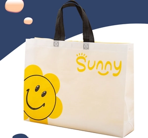 Detailed side view of large white non-woven bag with yellow sunflower smile and black handle