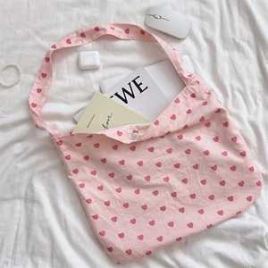 Detail of pink canvas tote bag showing interior snap button and heart print pattern