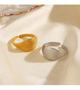 Detail of gold and silver textured 18K plated rings on silk showing adjustable open band