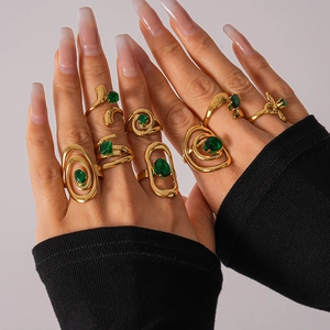 Close-up of a gold-plated ring set with green zircon stones worn by a model