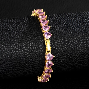 Close-up of pink heart-shaped gemstone tennis bracelet on elegant black leather background