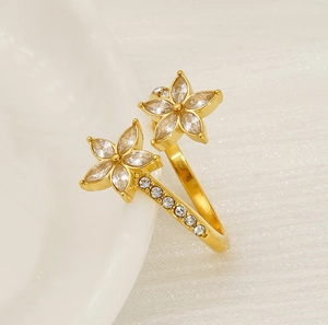 Close-up of golden floral open ring with sparkling white cubic zirconia stones