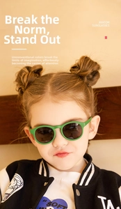 Close-up of green silicone round frame sunglasses on child model with UV protection