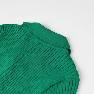 Détail du col en maille côtelée verte et de l'encolure sur une robe moulante élégante