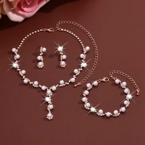 Close-up of golden jewelry set with white pearls and sparkling crystals on brown background