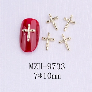 Dettaglio charm per unghie a croce dorata 7x10mm con strass neri su sfondo viola chiaro