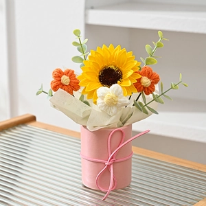 Detailed close-up of a handmade crochet sunflower bouquet in a pink gift container