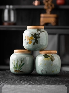 Detailed view of three ceramic tea canisters with ice-crackle glaze and floral rabbit motifs