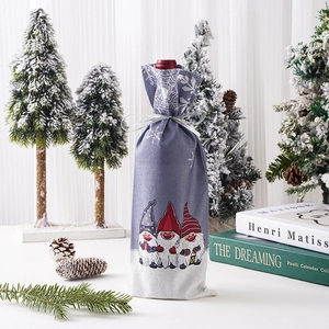 Detailed view of festive gnome wine bottle cover with snowflakes and silver ribbon bow