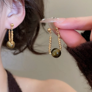 Dettaglio orecchini placcati oro 18k con pietre occhio di tigre e catene a spirale