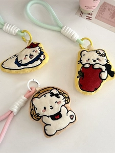 Three cute cartoon cat plush keychain charms with nautical, apple, and headphone designs