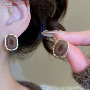 Detailed view of vintage oval brown flocked earrings with elegant gold metal edging