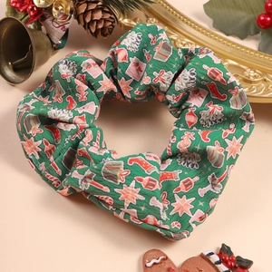 Detail of Christmas themed green scrunchie with holiday patterns and festive decor