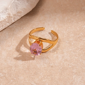 Macro detail of golden irregular wave ring featuring a four-prong set pink zircon stone