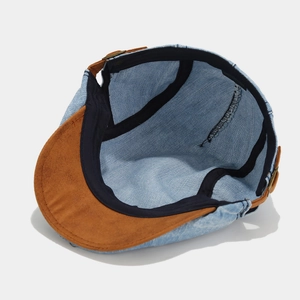 Detail view of denim beret featuring soft brown suede brim and adjustable inner strap