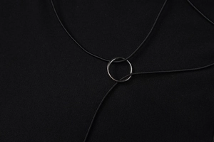Close-up of the black cord with a silver metal ring pendant on a Y-style necklace piece