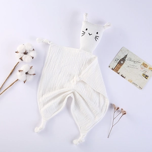 Close-up of white cotton muslin baby security blanket with cat head and knotted corners