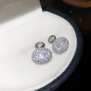 Macro shot of silver stud earrings with cluster cubic zirconia in a white velvet box