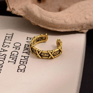 Bague croisée gravée en or vintage avec poinçon argent S925 sur un livre