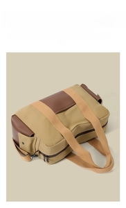 Close-up of side profile of khaki canvas travel bag with brown leather accents and hardware