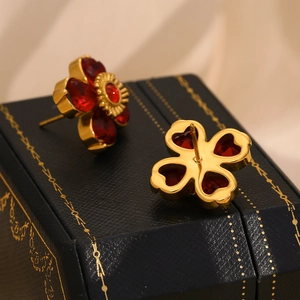 Vue macro de clous d'oreilles fleur plaqués or 18 carats avec cristal rouge sur boîte
