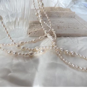 Detailed view of layered baroque freshwater pearl necklace on textured stone background