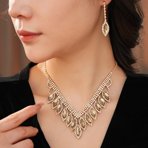 Detailed view of champagne teardrop tassel necklace and earrings set on model