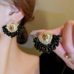 Vintage floral stud earrings with black crystals and red rhinestone details on a gold base