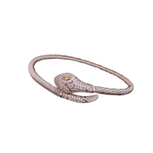 Vintage rose gold snake-shaped open bracelet with sparkling white stones and yellow gem eyes