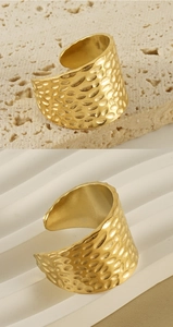 Macro detail of the golden hammered texture on this wide adjustable stainless steel ring