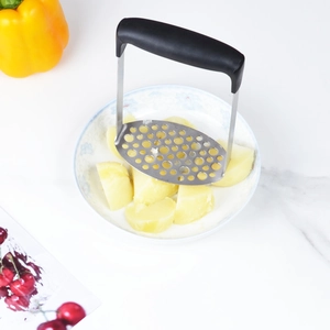 Presse-purée en acier inoxydable avec poignée noire écrasant des pommes de terre