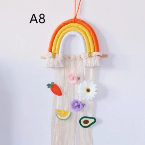 Detail of handmade cotton rainbow hair clip holder with fringe and colorful fruit clips