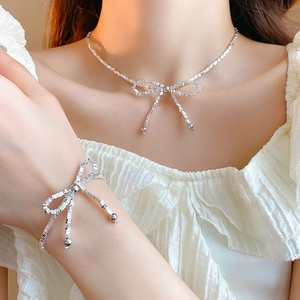 Détail de l'ensemble collier et bracelet à nœud argenté avec chaînes à maillons carrés