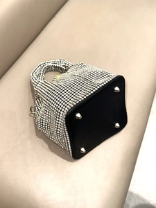 Luxury rhinestone bucket bag with silver diamonds and protective metal feet on leather base