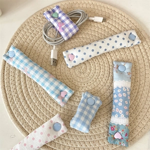 Close-up of floral fabric cable organizers with snap buttons for wire management