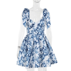 Détail d'une robe fleurie bleue avec bretelles à nœuds et décolleté en cœur