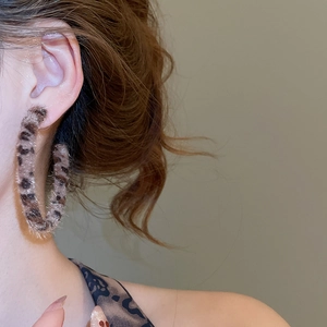 Close-up of model wearing leopard print plush hoop earrings with a vintage velvet texture