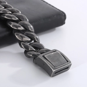Detail of vintage stainless steel Cuban link bracelet with hammered texture on leather