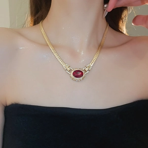 Detail of vintage oval red gemstone necklace with crystal pavé and flat gold chain link