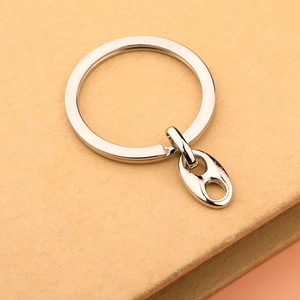 Detailed close-up of a silver metal keychain with a large ring and pig nose buckle charm