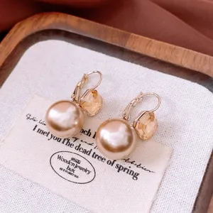 French vintage champagne pearl earrings with amber crystal pendant on wooden tray