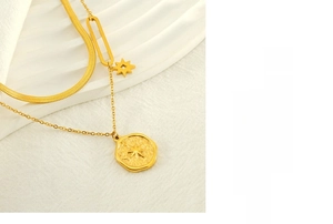 Close-up of golden double-layer necklace featuring a star pendant and coin relief