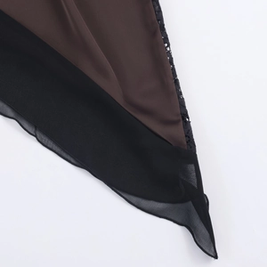 Détail du tissu satiné avec bordure en dentelle noire et ourlet irrégulier sur la robe