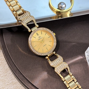 Gros plan détaillé d'une montre à quartz dorée de luxe avec lunette en strass brillants