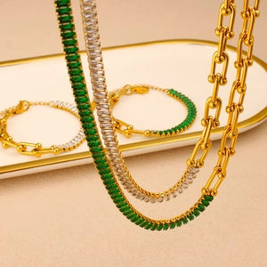 Macro detail of gold plated horseshoe chain set with green and white zircon gemstones